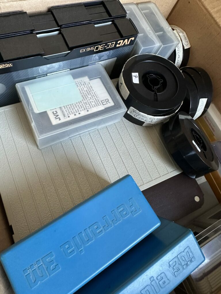 Carton rempli de cassettes VHS, Hi8 et MiniDV déposées au studio 3V Movie pour numérisation